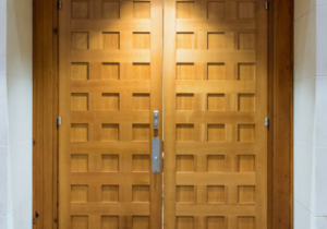 Two large, wooden city council chamber doors are closed.